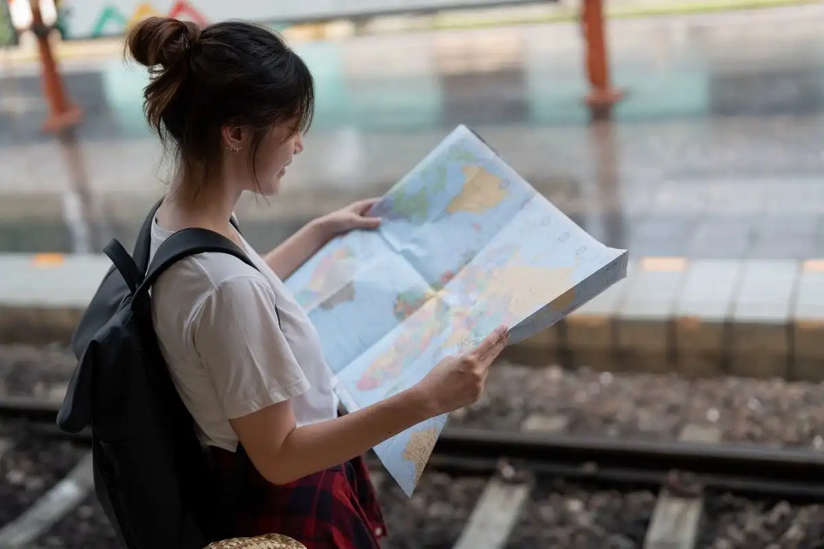 A traveller reading a paper map on a station platform