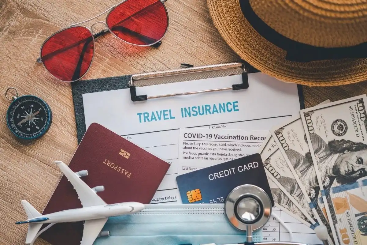 A travel insurance form with a passport, credit card and a model aeroplane