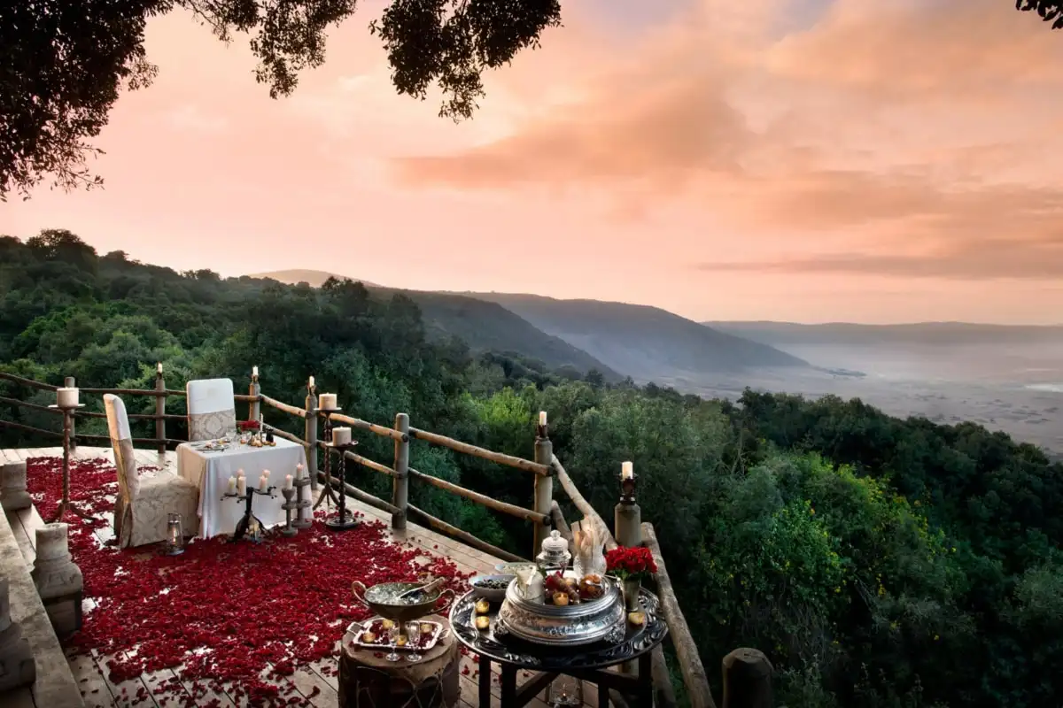 A candlelit dinner set on a deck above a valley at dusk