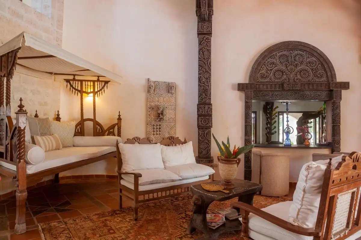 A sitting room with carved wooden furniture and a daybed