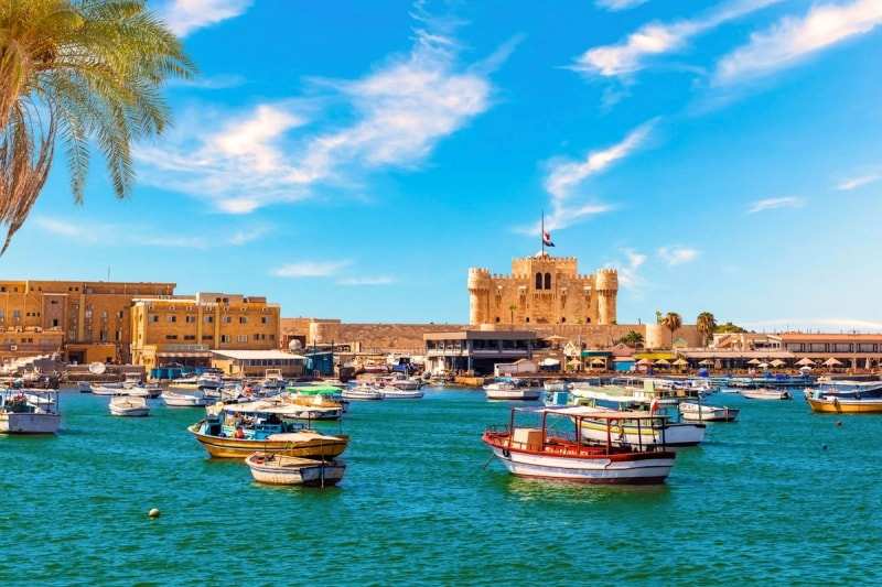 Small boats moored in the harbour at Alexandria below the Citadel of Qaitbay