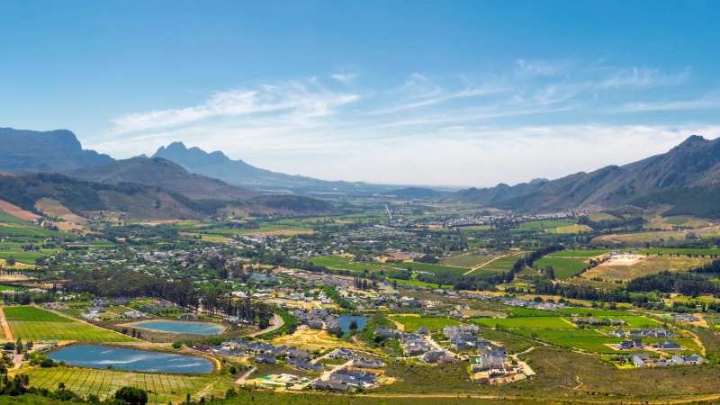 The Franschhoek valley from above, vineyards, farm dams and houses below the mountains