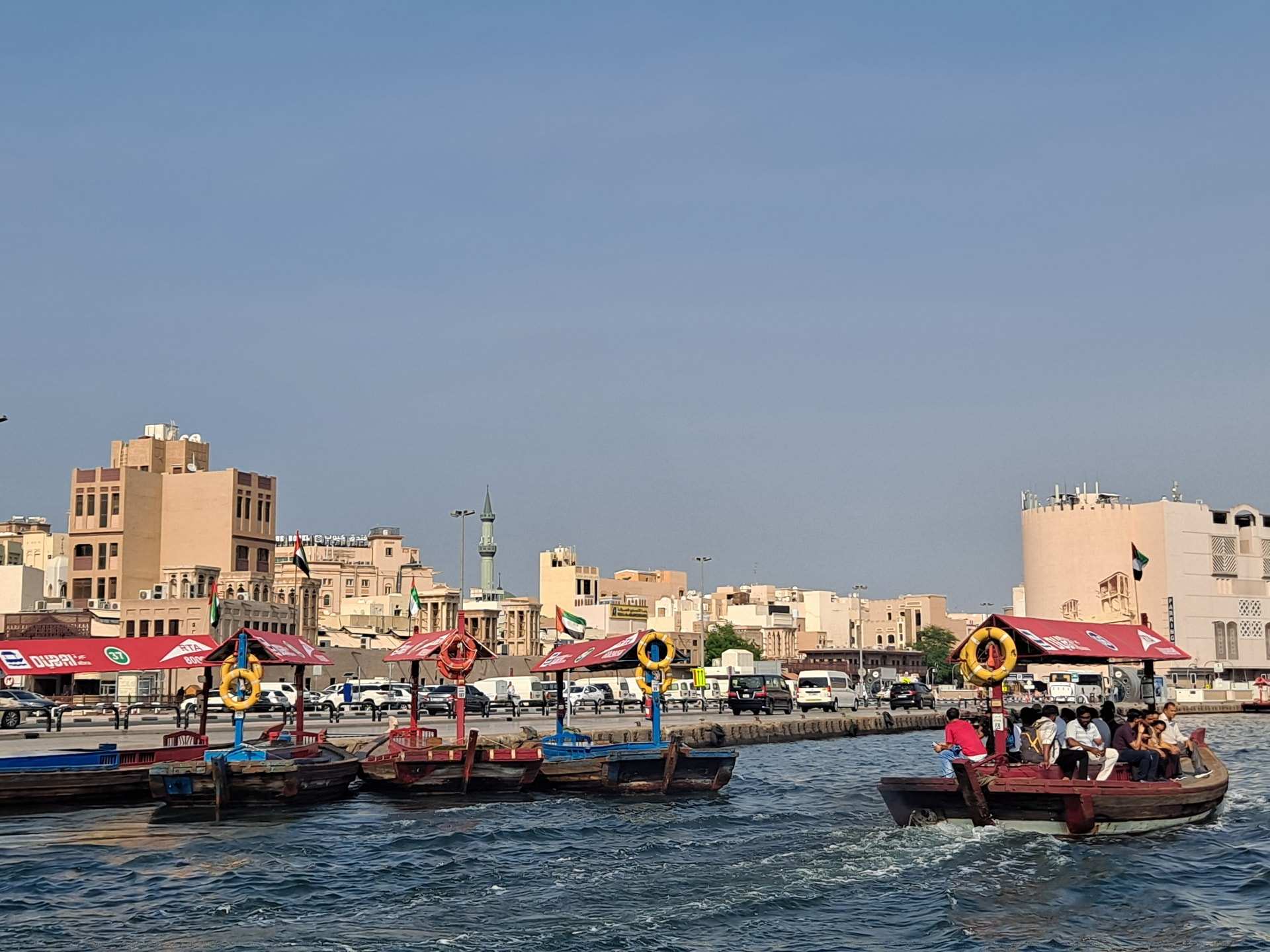 Wooden abras crossing Dubai Creek, the low waterfront of Deira behind them