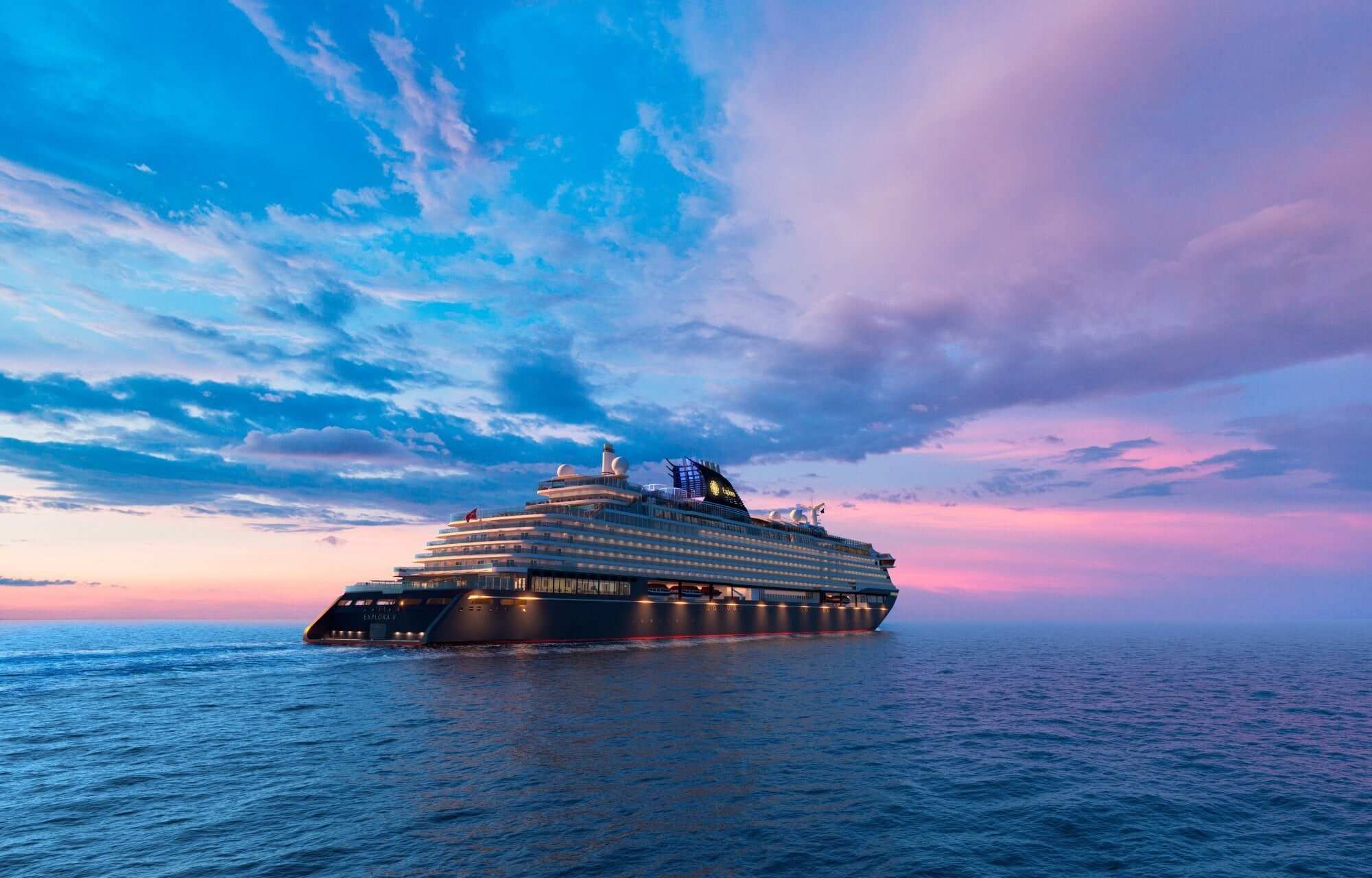 Explora II under way on open sea at dusk, her decks lit under a pink and blue sky