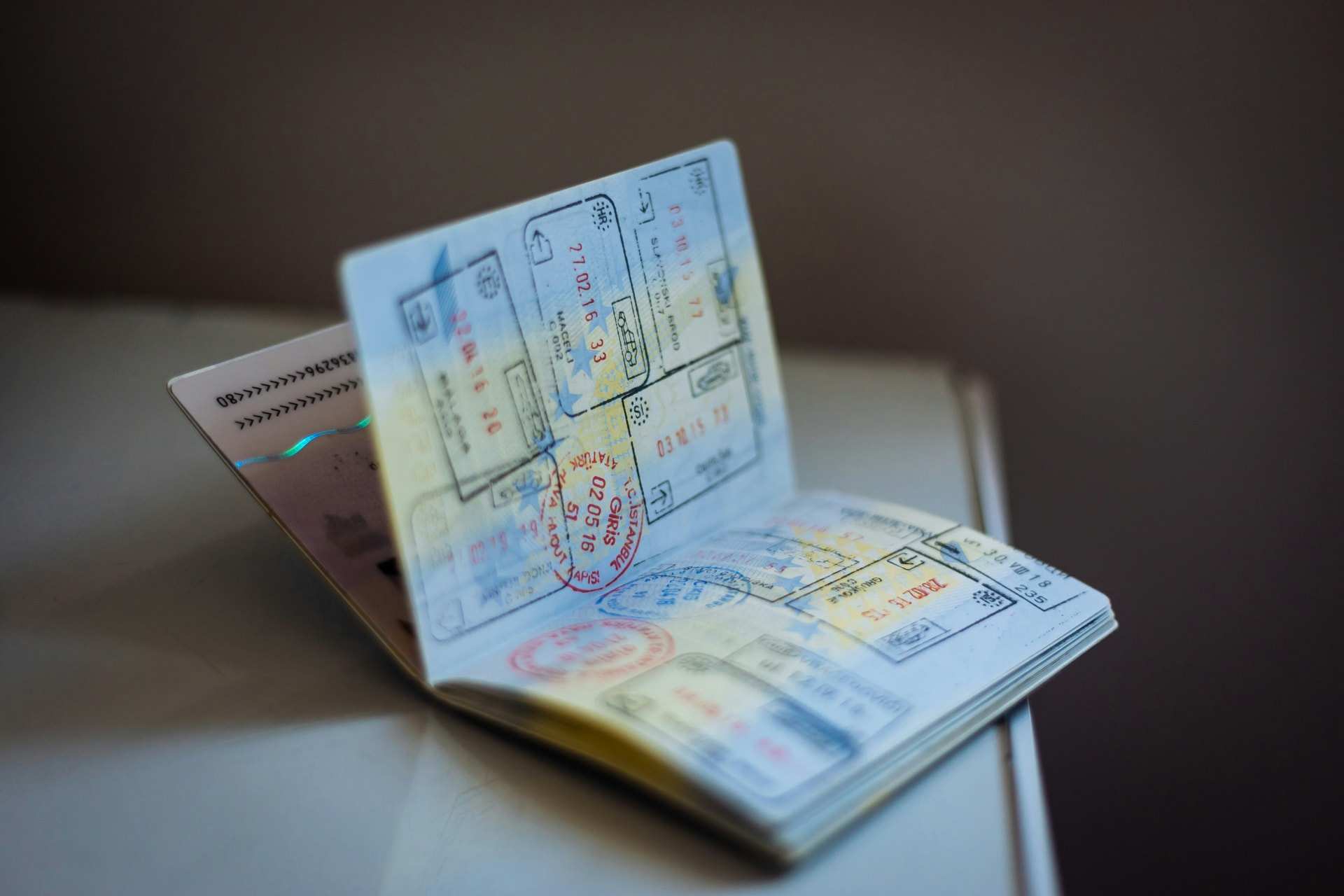 An open passport lying on a table, its pages covered in coloured entry and exit stamps