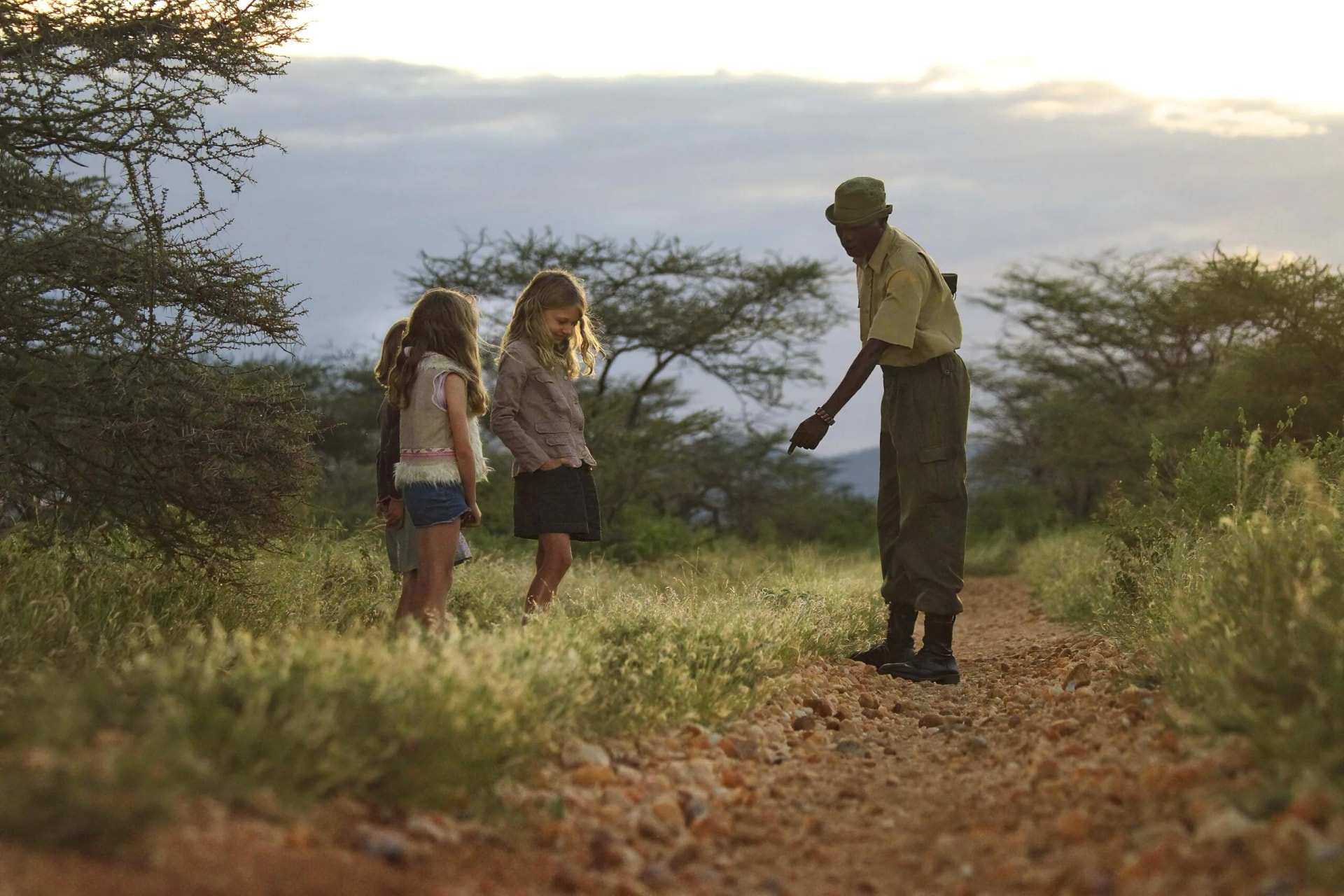 A guide showing two children something on a bush walk