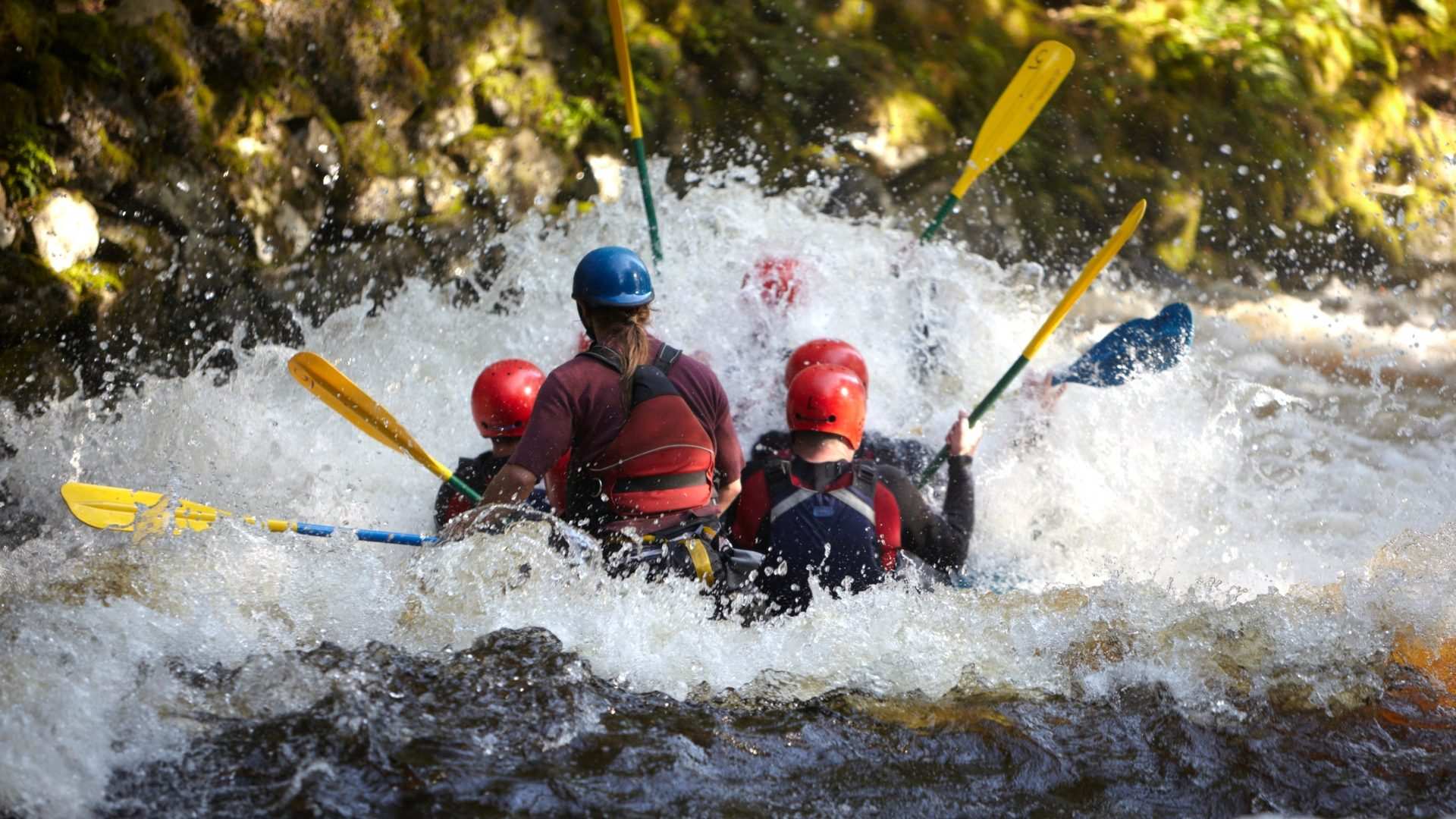 A raft crew paddling hard through a wall of white water on the Nile at Jinja